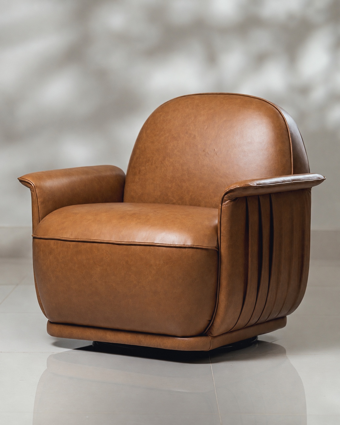 Poltrona de couro caramelo com desenho arredondado